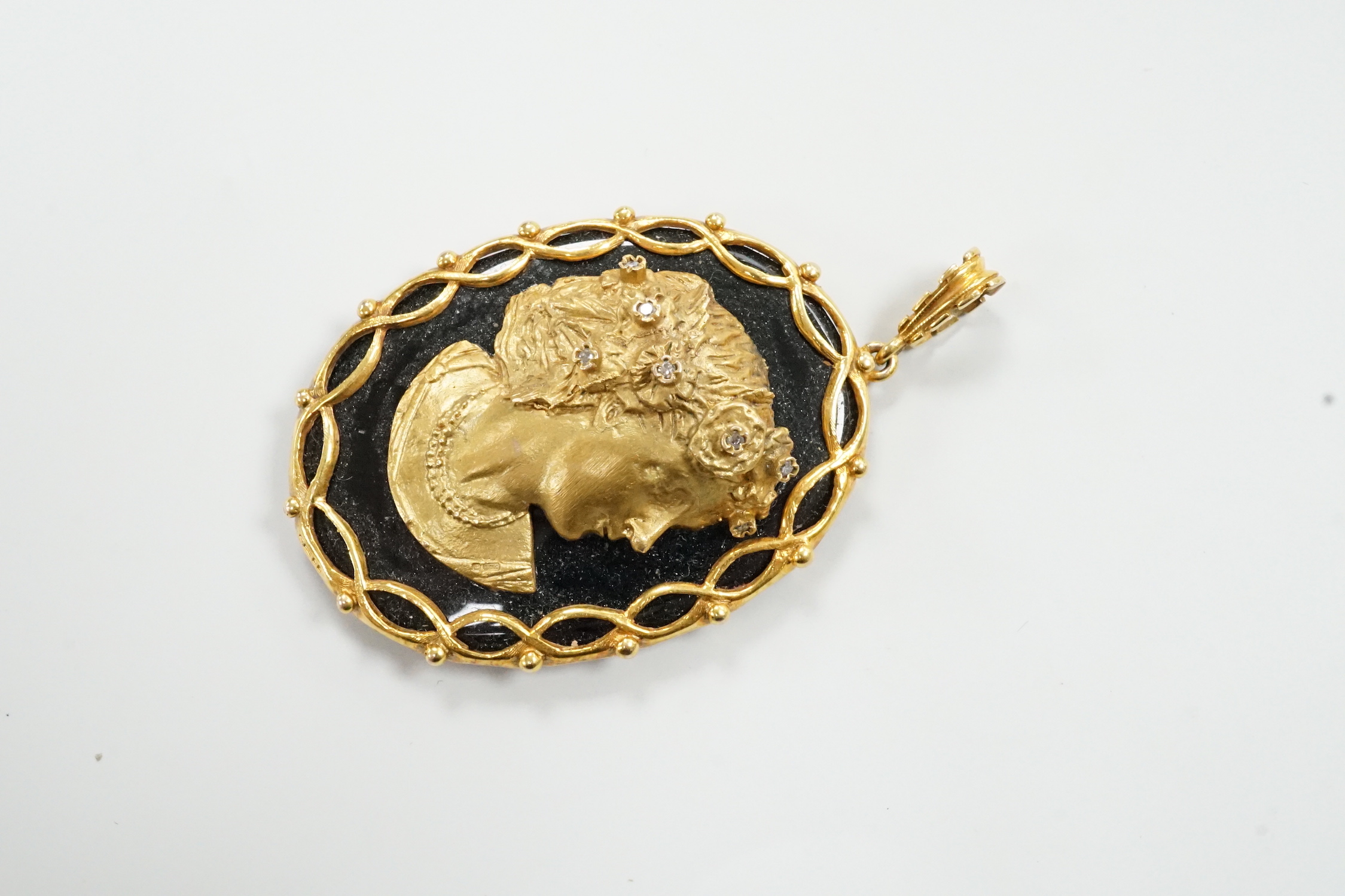A modern 9ct gold, and diamond set black onyx pendant, decorated with the bust of a lady in relief, overall 66mm, gross weight 35.4 grams.